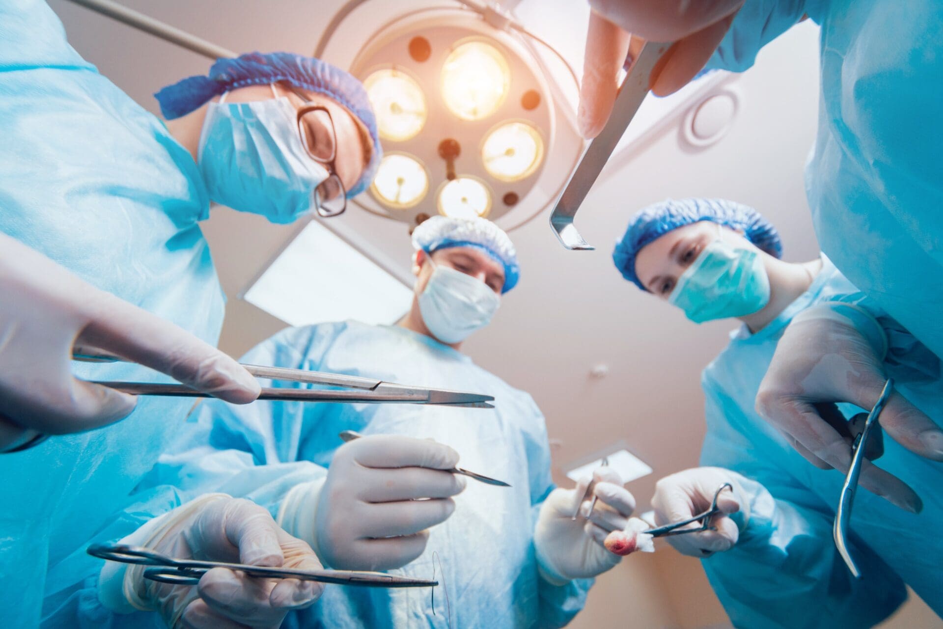Group of surgeons in operating room with surgery equipment